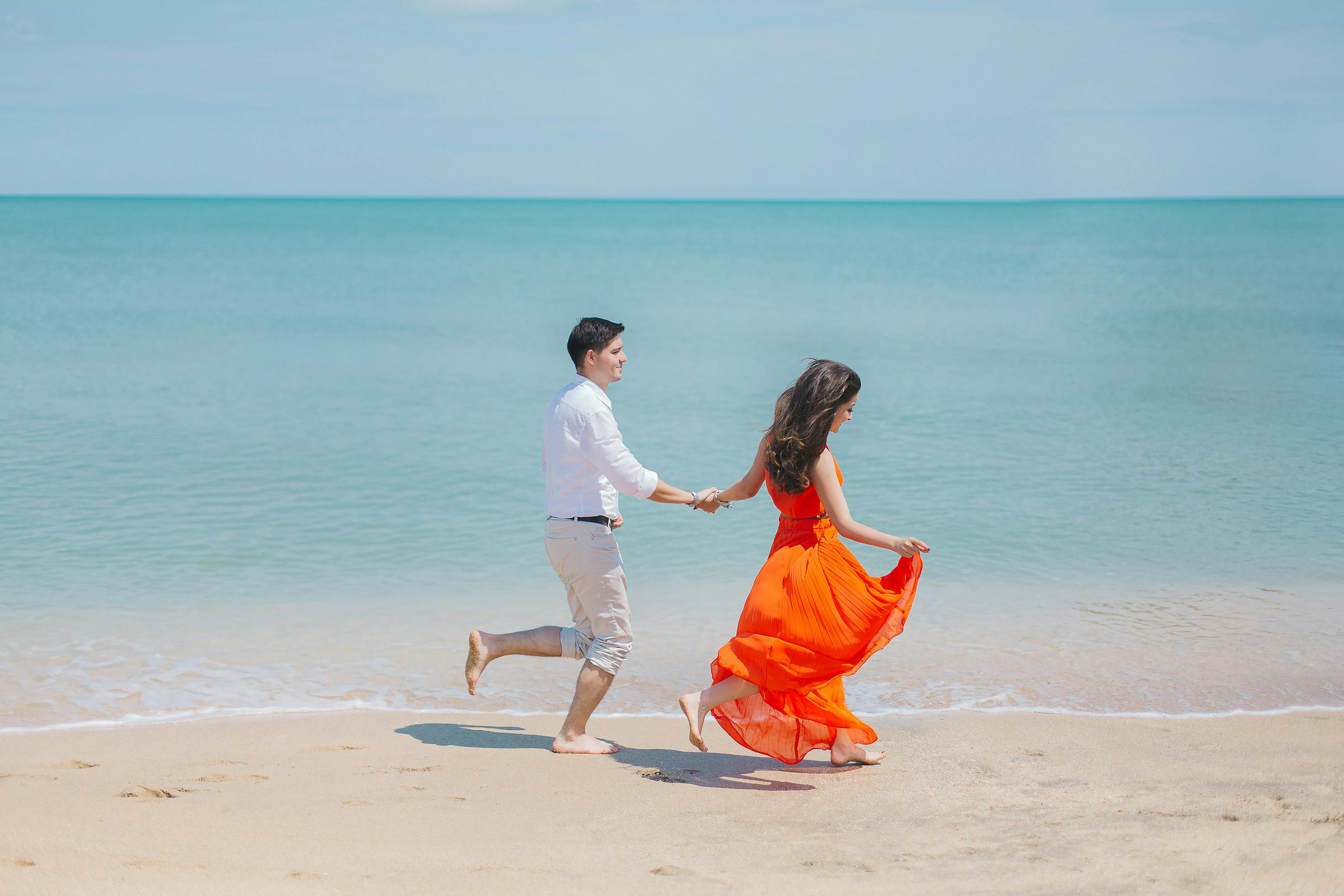 Joyful couple running on beach